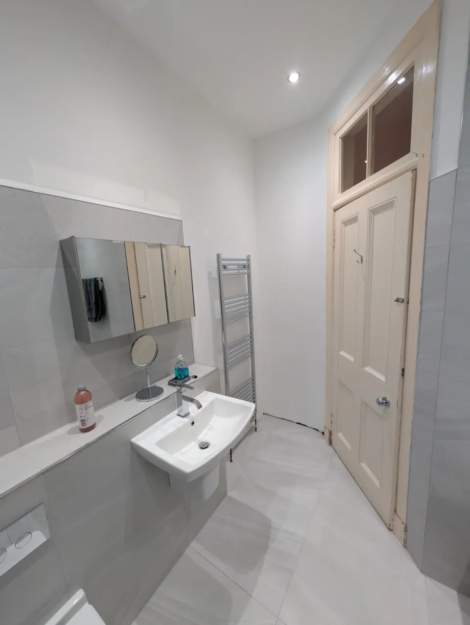 Wall-mounted basin and mirror in a grey bathroom