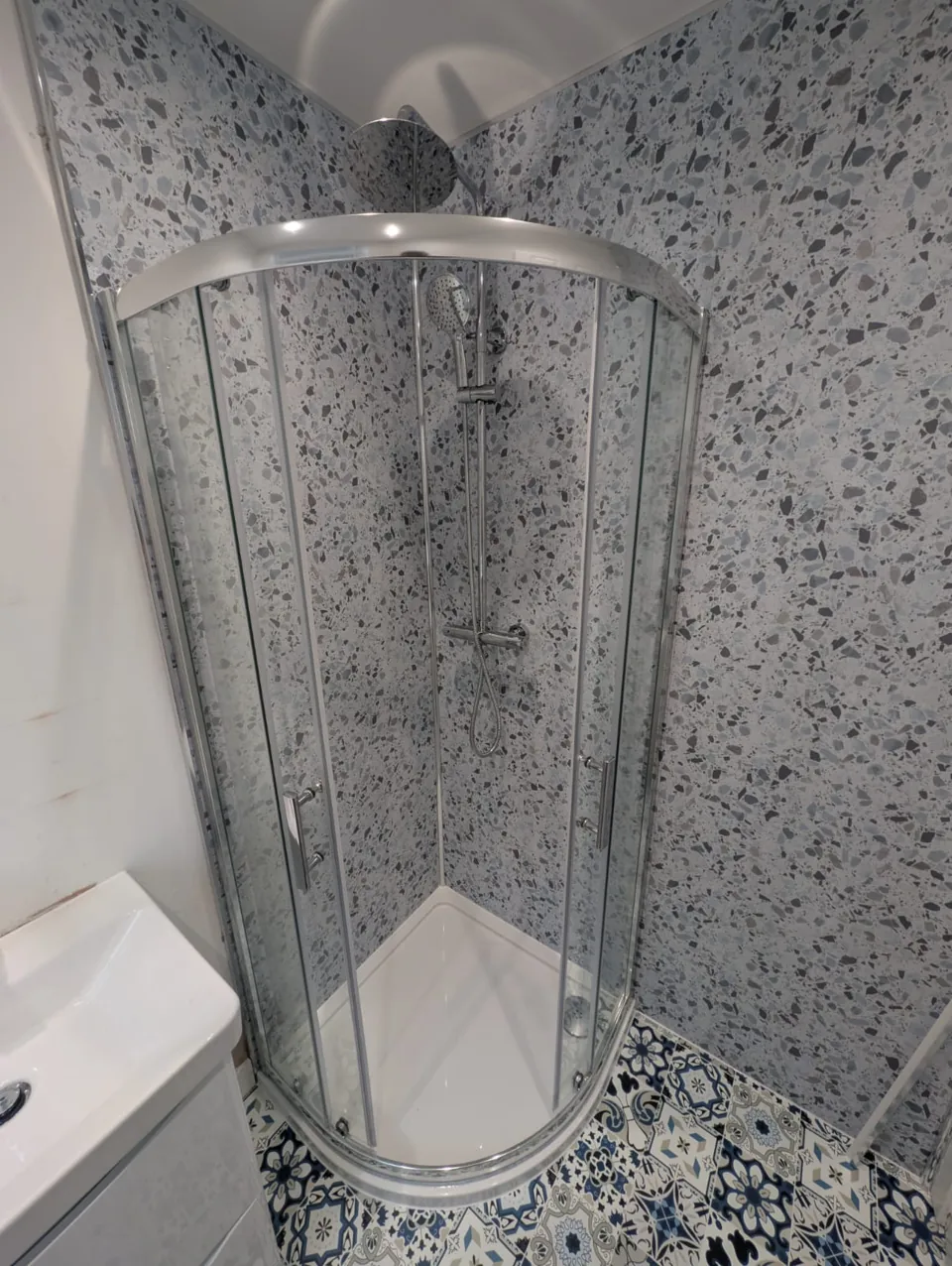 Curved shower enclosure with patterned walls and floor